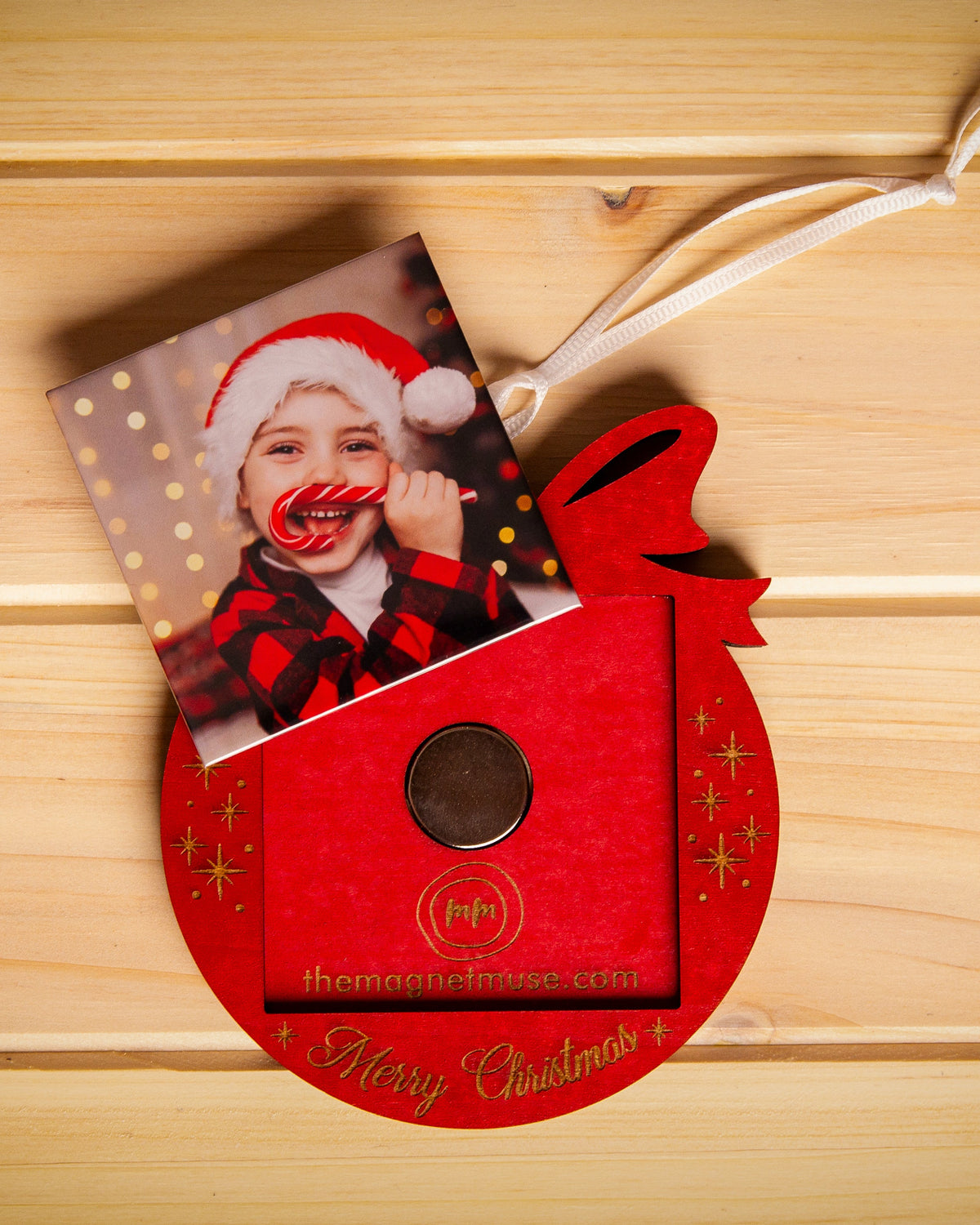 Removable custom photo magnet shown outside a red wooden holiday ornament