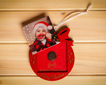 Removable custom photo magnet shown outside a red Merry Christmas wooden ornament