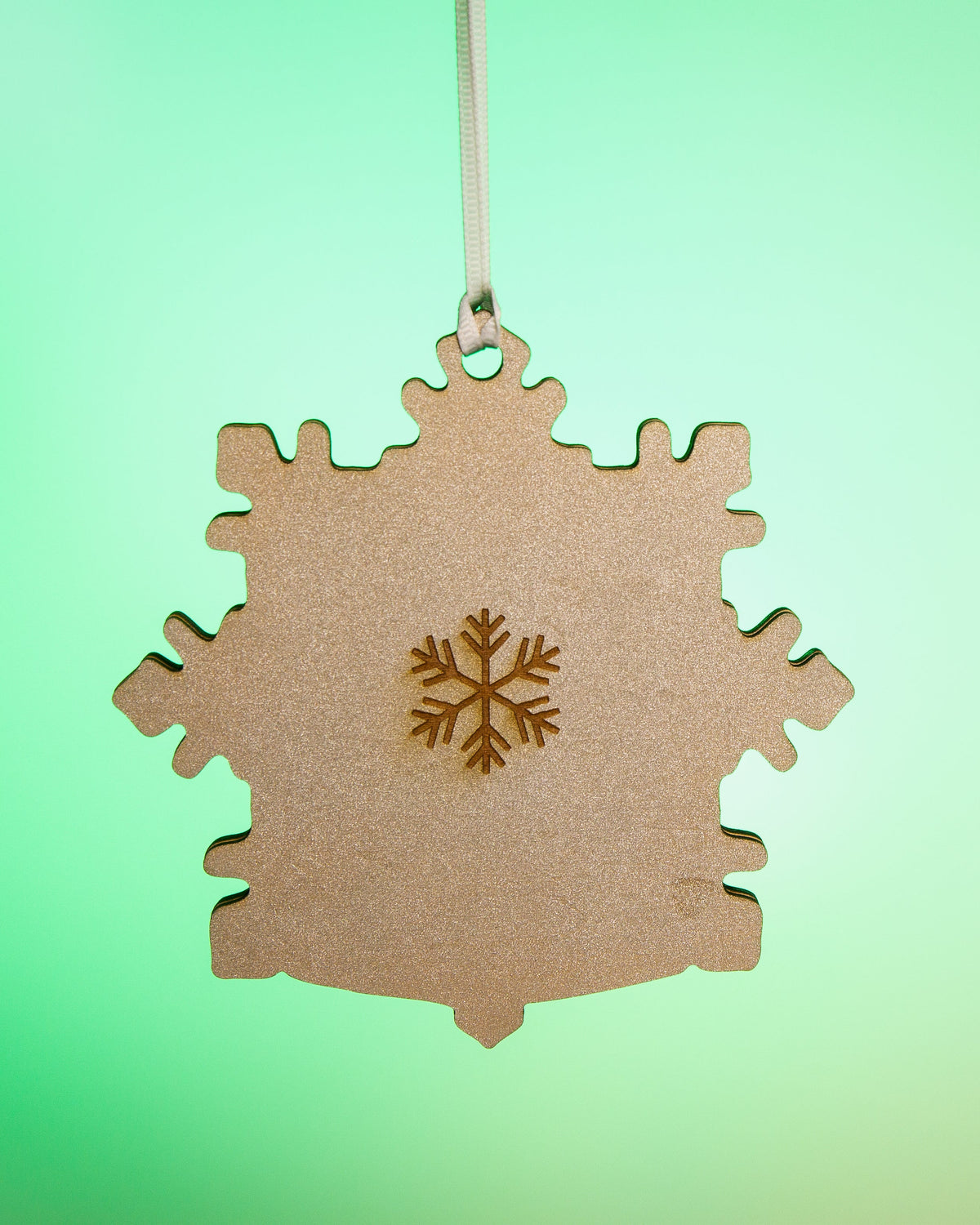 Back of silver snowflake photo magnet ornament showing removable magnet hardware and Magnet Muse engraving